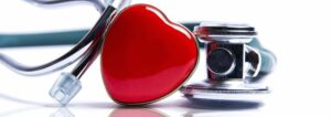 Green stethoscope with a red heart-shaped centerpiece, symbolizing heart health and medical care.